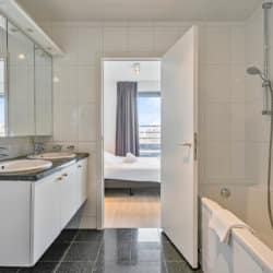 lavabo double, douche et baignoire dans une salle de bain pour un appartement de type bbf avec services, avec une chambre à coucher