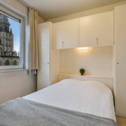 double bed with wardrobe storage and view onto church in sablon brussels