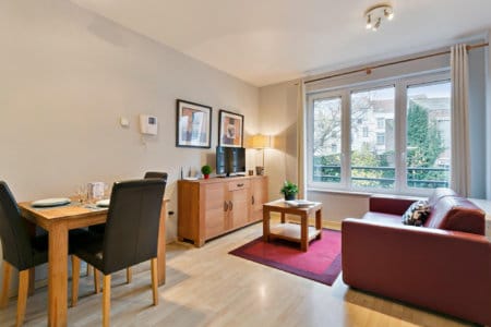 salon spacieux avec télévision par câble dans un appartement avec services à etterbeek