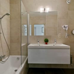 salle de bain avec double lavabo, douche et baignoire dans l'appartement du bbf