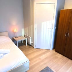 lit simple dans un appartement avec services de trois chambres dans le quartier européen