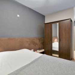 lit double avec armoire dans un appartement de deux chambres